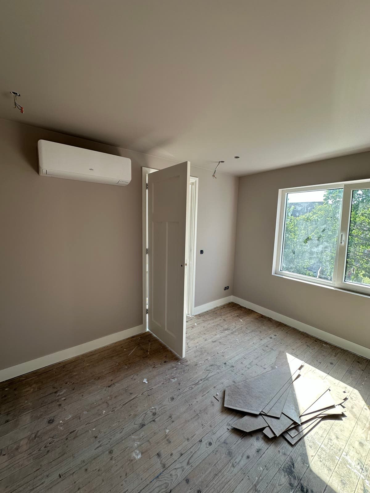 Vers gespoten slaapkamer in greige, muren en plafond in dezelfde kleur